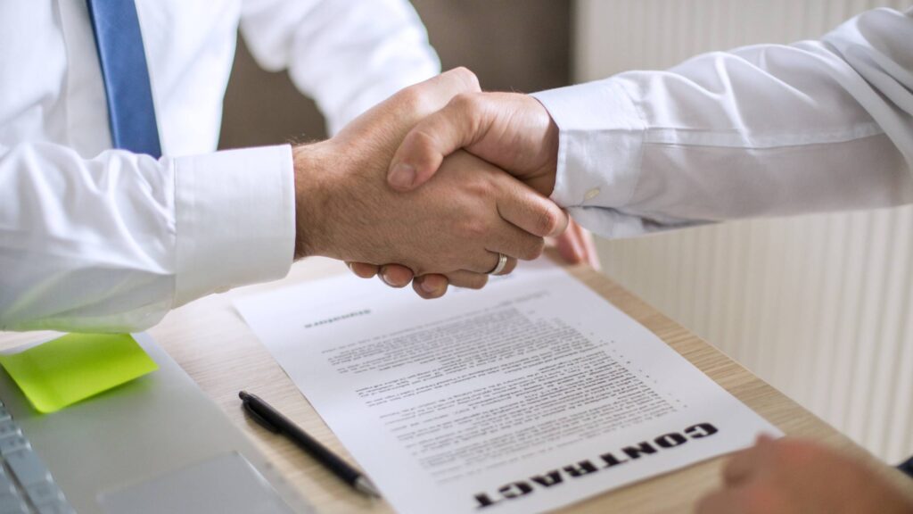 A manager shaking hands after outsourcing HR support